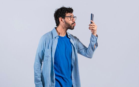 A man blowing kisses on the cell phone isolated, man taking selfie and blowing kisses on the cell phone, A guy blowing kisses on the phone, loving man sending kisses on the phone