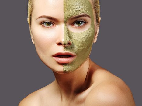 Beautiful Woman Applying Green Facial Mask. Beauty Treatments. Close-up Portrait of Spa Girl Apply Clay Facial mask on grey background