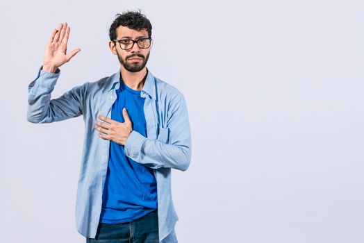 Man swearing honesty and devotion, Honest man raising his hand, a A guy raising his hand swearing, young man raising a hand promising something