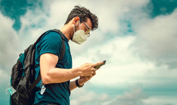 Adventurous man in the field with phone, man with backpack in the field chatting