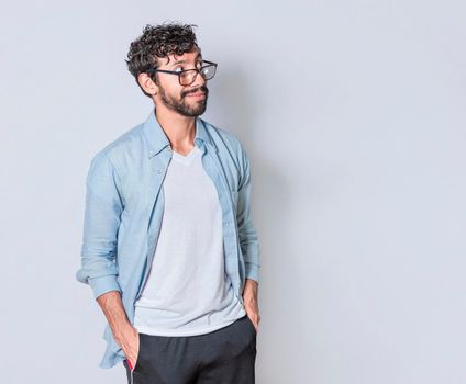 young man wondering with hand in pocket over isolated background, handsome guy thinking looking to side