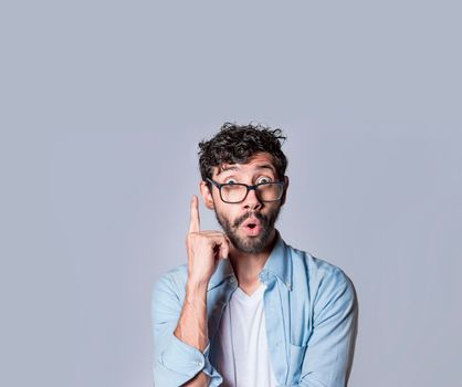 Shocked young man with new idea, shocked guy pointing finger up