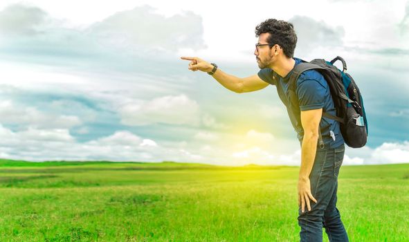 Adventurous man in the field, man with backpack in the field looking