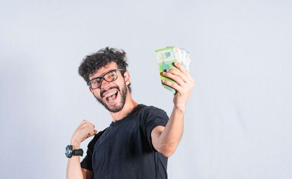 Excited man with money in hand, happy man holding banknotes in hand, earning and savings concept