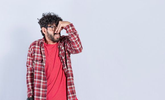 A man with covering his nose, a guy with a face of unpleasant odors, concept of bad smells