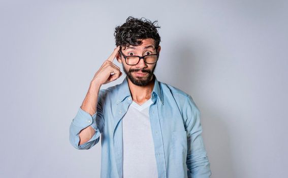 young man wondering with his finger on isolated background, A guy thinking with his finger on his head.