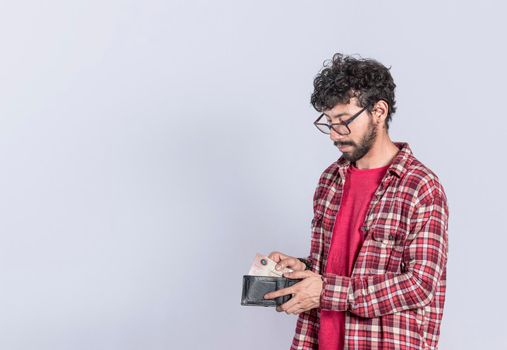man taking bills out of his wallet, a guy taking money out of his wallet on isolated background