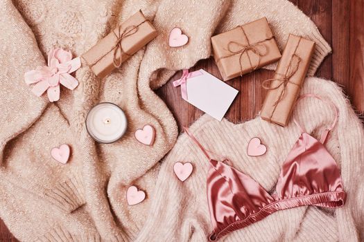 Cozy Winter Flatlay with Heart Shape Candles, Gifts and Warm Knitted Plaid. Pink Still life for St. Valentine's Day. Relax in Weekend for Woman. Hygge Style.