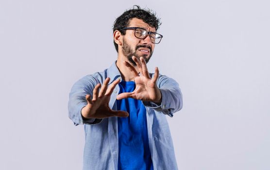 a man with rejection expression, man with scared expression on his face making frightened gesture with his palms, scared man asking you to stop