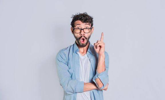Shocked young man with new idea, shocked guy pointing finger up