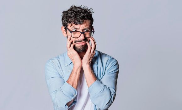 Puzzled man on isolated background, face of a puzzled and skeptical guy on isolated background