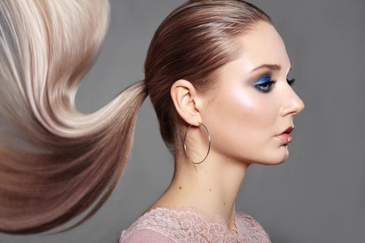 Beautiful Girl with Ponytail Hairstyle. Blond Shiny Straight Hair, Fashion Makeup on Model Face. Woman with Healthy Skin and Party Glitter Make-up