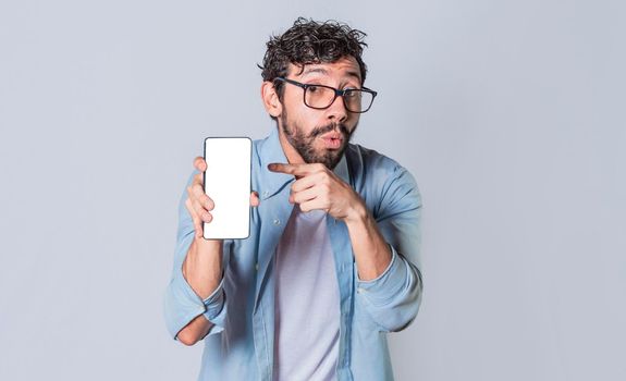 Young man showing blank cell phone screen, guy showing and pointing at his cell phone screen