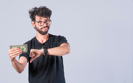Sad man holding banknote, Sad man with a banknote with thumb down, concept of man with little money