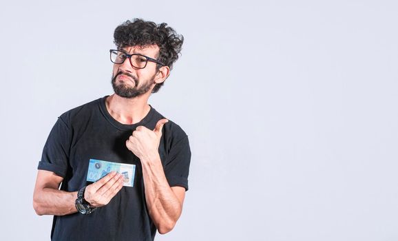 Convinced man holding a banknote in his hand, Thumbs up man holding a banknote, Thumbs up banknote man concept