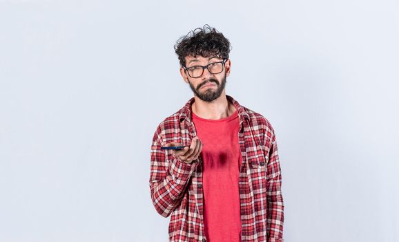skeptical man with cell phone in hand, man with indifferent and sad face, Sad man with cell phone in hand