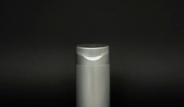 Gray bottle of shampoo, conditioner, hair rinse, mouthwash, on a black background