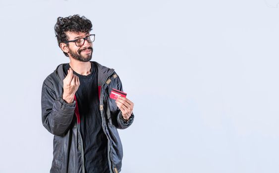Handsome man holding credit card, guy in glasses holding credit card smiling, electronic payment concept
