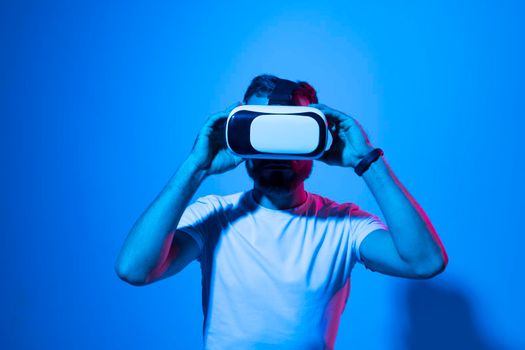 Vitrual reality concept. Man are playing a game in virtual reality. Young man in VR glasses are gaming with realistic holograms in simulator. Entertainment and leisure concept. Modern technologies