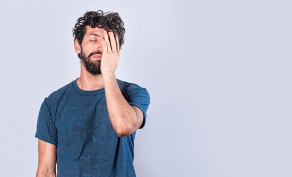 Tired and distressed man covering his face with his palm, Concept of a bored and tired man