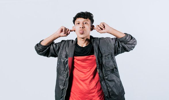 Person sticking out tongue making fun, Man covering ears and sticking out tongue, guy covering his ears making fun, man with hands on ears and making fun