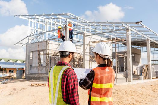 Back two architect and client discussing help create plan with blueprint home building at construction site. Asian engineer foreman worker man and woman meeting talking on drawing paper project