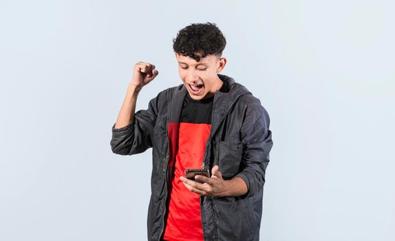 Happy man holding a smartphone and celebrating, Excited guy looking at his smartphone