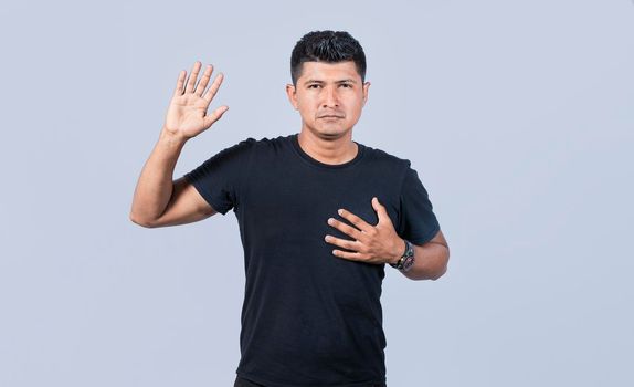 Honest man raising his hand, a A guy raising his hand swearing, Man swearing honesty and devotion, young man raising a hand promising something