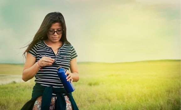 woman in the field drinking water, concept of woman in the field drinking water