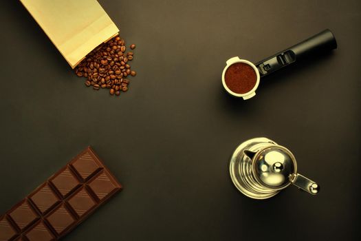 Coffee espresso in a holder, coffee-beans, bar of chocolate, coffee-pot