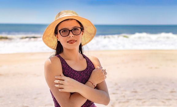 Pretty woman with hat on the beach, portrait of latin girl with hat on the beach