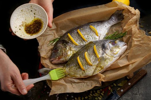 Raw dorado fish with spices cooking on cutting board.