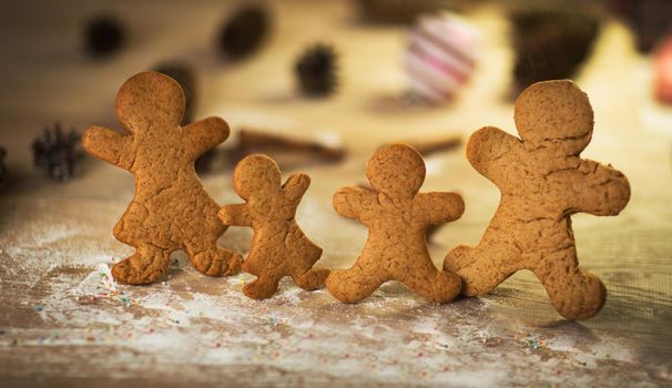 Gingerbread men made on the wooden table plate with gumdrops