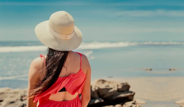 woman in hat from back to the sea, girl in hat looking to the sea, vacation concept, rear view of a girl watching the sea