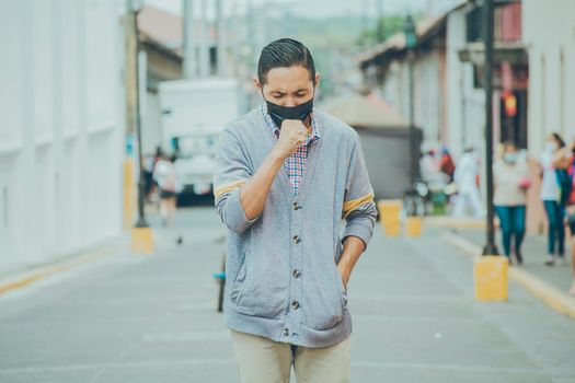 Coughing man with surgical mask, man with mask coughing in the street, concept of people with respiratory problems