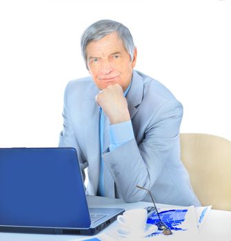 The businessman at the age of works for the laptop. Isolated on a white background.