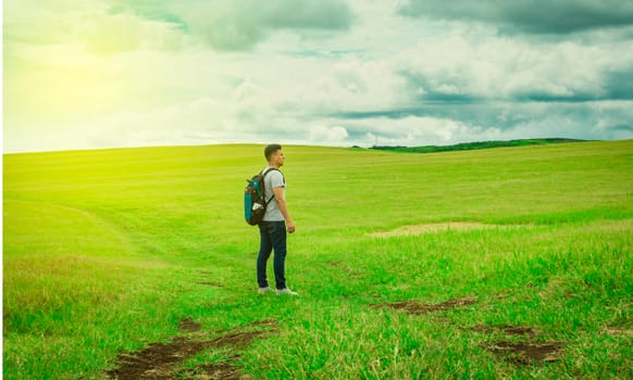 Adventurous man in the field, man with backpack in the field looking