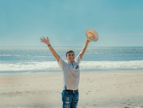 Happy handsome man on vacation outdoors, Happy latin young man on the beach, Tourist travel concept