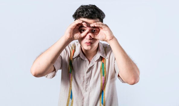 Man making binoculars gesture, Curious man making binoculars gesture, Guy on isolated background making binoculars gesture, man using his fists as binoculars