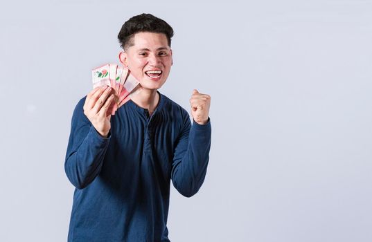 Excited man with money in his hand, astonished man with banknotes in his hand, concept of man earning money