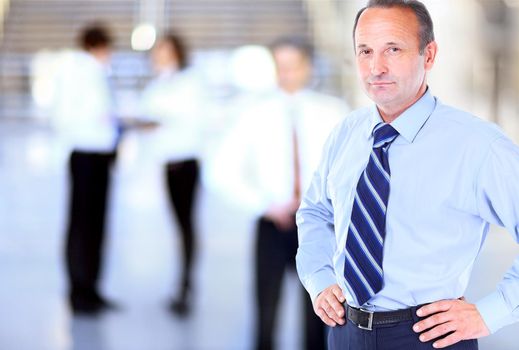 Happy mature business man looking at camera with satisfaction at office