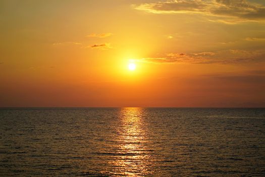 Beautiful colorful sunset at the sea with dramatic clouds and sun shining. Beauty world natural outdoors travel background.