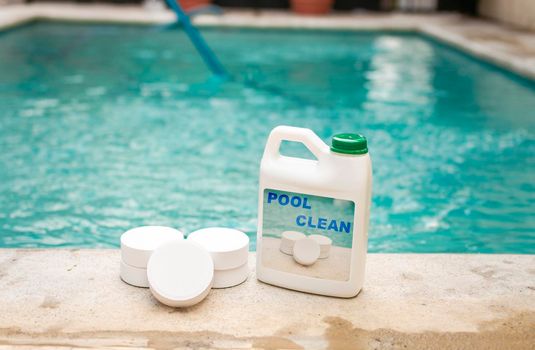 Pool cleaning chlorine tablets kit, pool cleaning chlorine tablets close up on the edge of a swimming pool, pool sanitizing chlorine tablets concept