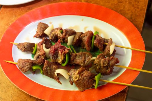 Roast beef served on a plate, roast beef skewers, three roast beef skewers on a plate