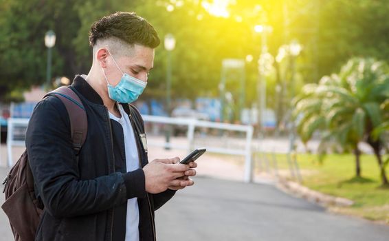 Handsome guy texting with his phone, Handsome young man in face mask texting with his phone, Handsome man texting on his phone