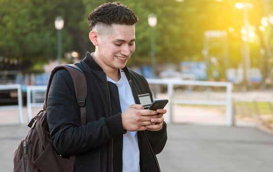 Handsome guy texting with his phone, Handsome young man in face mask texting with his phone, Handsome man texting on his phone