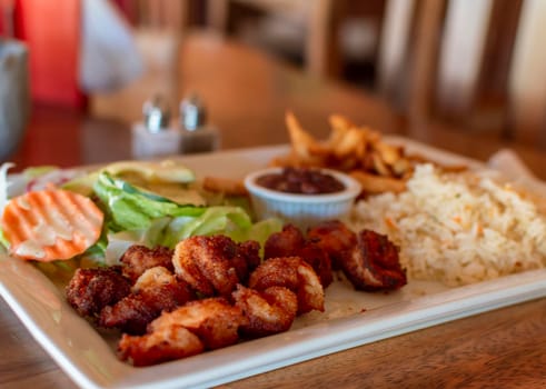 Plate of breaded shrimp with rice on the table with COPY SPACE, menu of breaded shrimp served on wooden table