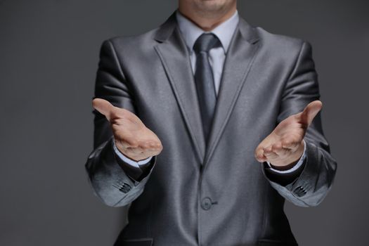 close up.businessman showing open palms.isolated on black background.