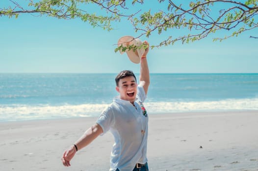 Happy handsome man on vacation outdoors, Happy latin young man on the beach, Tourist travel concept