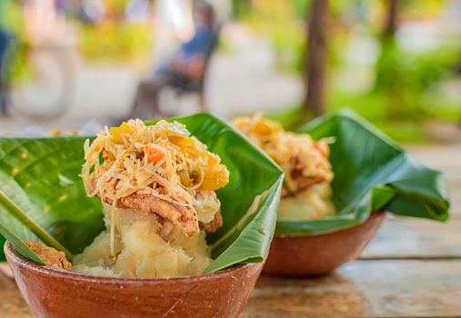 Vigorón with leaves served on a wooden table, two vigorones served on wooden background, vigorón typical food from nicaragua